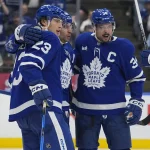 Oct 28, 2025; Toronto, Ontario, CAN; Toronto Maple Leafs forward John Tavares (91) and forward Auston Matthews (34) celebrate a goal by forward Matthew Knies (23) against the Calgary Flames during the third period at Scotiabank Arena. Mandatory Credit: John E. Sokolowski-Imagn Images