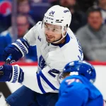Jan 12, 2026; Denver, Colorado, USA; Toronto Maple Leafs center Scott Laughton (24) takes a shot on goal in the first period at Ball Arena. Mandatory Credit: Ron Chenoy-Imagn Images
