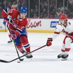 Feb 25, 2025; Montreal, Quebec, CAN; Montreal Canadiens left wing Juraj Slafkovsky (20) plays the puck against Carolina Hurricanes center Sebastian Aho (20) in the first period at Bell Centre.