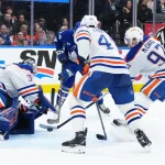 Dec 13, 2025; Toronto, Ontario, CAN; Edmonton Oilers center Connor McDavid (97) battles for the puck with Toronto Maple Leafs center Bobby McMann (74) in front of the net during the third period at Scotiabank Arena.