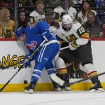 Apr 11, 2026; Denver, Colorado, USA; Colorado Avalanche defenseman Sam Malinski (70) and Vegas Golden Knights center Colton Sissons (10) battle for the puck in the first period at Ball Arena.