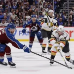 May 20, 2026; Denver, Colorado, USA; Colorado Avalanche defenseman Devon Toews (7) and Vegas Golden Knights center Brett Howden (21) reach for the puck during the third period in game one of the Western Conference Final of the 2026 Stanley Cup Playoffs at Ball Arena. Mandatory Credit: Isaiah J. Downing-Imagn Images