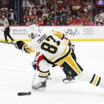 Apr 12, 2026; Washington, District of Columbia, USA; Pittsburgh Penguins center Sidney Crosby (87) shoots the puck as Washington Capitals defenseman Cole Hutson (44) defends during the second period at Capital One Arena.