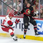 Apr 25, 2026; Ottawa, Ontario, CAN; Carolina Hurricanes defenseman Sean Walker (26) and Ottawa Senators center Tim Stutzle (18) battle for the puck in the third period of game four of the first round of the 2026 Stanley Cup Playoffs at the Canadian Tire Centre.