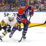 Jan 22, 2026; Edmonton, Alberta, CAN; Pittsburgh Penguins forward Connor Dewer (19) gets a shot away in front of Edmonton Oilers defensemen Evan Bouchard (2) during the second period at Rogers Place. Mandatory Credit: Perry Nelson-Imagn Images