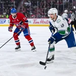 Jan 12, 2026; Montreal, Quebec, CAN; Vancouver Canucks center Elias Pettersson (40) plays the puck against Montreal Canadiens center Nick Suzuki (14) during the third period at Bell Centre. Mandatory Credit: David Kirouac-Imagn Images