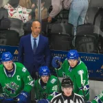 Abbotsford head coach Manny Malhotra watches his team from the bench during the first period of their game at Acrisure Arena in Palm Desert, Calif., Wednesday, Jan. 29, 2025.