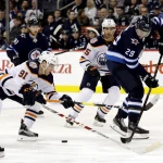 Dec 13, 2018; Winnipeg, Manitoba, CAN; Edmonton Oilers left wing Drake Caggiula (91) gets control of the puck against Winnipeg Jets right wing Patrik Laine (29) in the second period at Bell MTS Place. Mandatory Credit: James Carey Lauder-Imagn Images