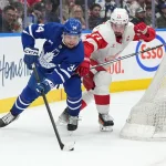 Apr 13, 2024; Toronto, Ontario, CAN; Toronto Maple Leafs center Auston Matthews (34) battles for the puck behind the net with Detroit Red Wings center Dylan Larkin (71) during the third period at Scotiabank Arena. Mandatory Credit: Nick Turchiaro-Imagn Images