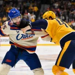 Jan 13, 2026; Nashville, Tennessee, USA; Edmonton Oilers defenseman Darnell Nurse (25) and Nashville Predators right wing Michael McCarron (47) exchange punches during the first period at Bridgestone Arena.