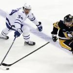 Nov 26, 2022; Pittsburgh, Pennsylvania, USA; Toronto Maple Leafs center Auston Matthews (34) and Pittsburgh Penguins center Sidney Crosby (87) reach for the puck during the third period at PPG Paints Arena. Toronto won 4-1.