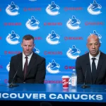Jun 4, 2026; Vancouver, BC, CANADA; General manager Ryan Johnson listens to Manny Malhotra speak during press conference where the Vancouver Canucks introduce Malhotra as their new head coach during a press conference at Rogers Arena.