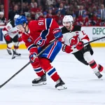 5 avril 2026; Montréal, Québec, Canada; Oliver Kapanen (91), centre des Canadiens de Montréal, joue la rondelle contre Nico Hischier (13), centre des Devils du New Jersey, durant la troisième période au Centre Bell.