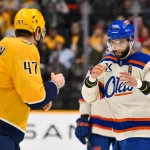 Jan 13, 2026; Nashville, Tennessee, USA; Nashville Predators right wing Michael McCarron (47) and Edmonton Oilers defenseman Darnell Nurse (25) during the first period at Bridgestone Arena.