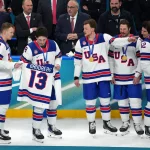 Feb 22, 2026; Milan, Italy; Brady Tkachuk and Zach Werenski of the United States hold a jersey in memory of Johnny Gaudreau after winning the men's ice hockey gold medal game during the Milano Cortina 2026 Olympic Winter Games at Milano Santagiulia Ice Hockey Arena.