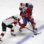 8 février 2022; Montréal, Québec, Canada; L'ailier droit des Canadiens de Montréal, Brendan Gallagher (11), joue la rondelle contre le centre des Devils du New Jersey, Yegor Sharangovich (17) et le centre Nico Hischier (13), durant la première période au Centre Bell.