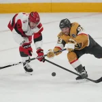 Jun 14, 2026; Las Vegas, Nevada, USA; Vegas Golden Knights right wing Mitch Marner (93) reaches for the puck against Carolina Hurricanes defenseman Alexander Nikishin (21) during the first period in game six of the 2026 Stanley Cup Final at T-Mobile Arena.