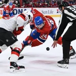 Un centre est retiré des plans du Canadien et Kent Hughes devra faire un choix 5 avril 2026 ; Montréal, Québec, Canada ; Steve Barton (59), juge de ligne de la LNH, lance la rondelle lors d\'une mise en jeu opposant Nico Hischier (13), centre des Devils du New Jersey, à Phillip Danault (24), centre des Canadiens de Montréal, au cours de la première période au Centre Bell.