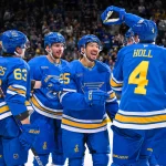 Mar 28, 2026; St. Louis, Missouri, USA; St. Louis Blues defenseman Justin Holl (4) is congratulated by right wing Jordan Kyrou (25) left wing Jake Neighbours (63) and left wing Pavel Buchnevich (89) after scoring against the Toronto Maple Leafs during the second period at Enterprise Center.