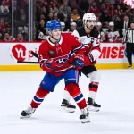 5 avril 2026; Montréal, Québec, Canada; Cole Caufield (13), ailier droit des Canadiens de Montréal, et Nico Hischier (13), centre des Devils du New Jersey, suivent le jeu du regard durant la troisième période au Centre Bell.