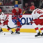 25 février 2025; Montréal, Québec, Canada; Owen Beck (62), centre des Canadiens de Montréal, défend la rondelle face au défenseur des Hurricanes de la Caroline, Shayne Gostisbehere (4), et au centre Jesperi Kotkaniemi (82), en deuxième période au Centre Bell.