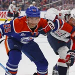 Jan 24, 2026; Edmonton, Alberta, CAN; Edmonton Oilers defensemen Darnell Nurse (25) and Washington Capitals forward Ryan Leonard (9) battle for a loose puck during the second period at Rogers Place. Mandatory Credit: Perry Nelson-Imagn Images
