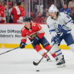 Apr 8, 2025; Sunrise, Florida, USA; Toronto Maple Leafs defenseman Chris Tanev (8) moves the puck ahead of Florida Panthers right wing Mackie Samoskevich (25) during the second period at Amerant Bank Arena.