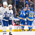 Mar 28, 2026; St. Louis, Missouri, USA; St. Louis Blues left wing Dylan Holloway (81) is congratulated by right wing Jordan Kyrou (25) and left wing Jake Neighbours (63) after scoring against the Toronto Maple Leafs during the third period at Enterprise Center.