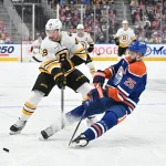 Dec 31, 2025; Edmonton, Alberta, CAN; Boston Bruins center Elias Lindholm (28) battles for the puck with Edmonton Oilers defenseman Darnell Nurse (25) during the second period at Rogers Place.