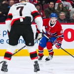 2 décembre 2025; Montréal, Québec, Canada; le défenseur des Canadiens de Montréal, Lane Hutson (48), joue la rondelle contre l'ailier gauche des Sénateurs d'Ottawa, Brady Tkachuk (7), durant la deuxième période au Centre Bell.