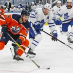 Feb 27, 2021; Edmonton, Alberta, CAN; Edmonton Oilers forward Connor McDavid (97) carries the puck around Toronto Maple Leafs defensemen Morgan Rielly (44) during the first period at Rogers Place.