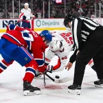 7 décembre 2024; Montréal, Québec, Canada; Mark Shewchyk (92), juge de ligne de la LNH, effectue la mise au jeu entre Kirby Dach (77), centre des Canadiens de Montréal, et Hendrix Lapierre (29), centre des Capitals de Washington, durant la troisième période au Centre Bell.