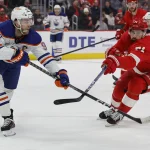 Jan 11, 2024; Detroit, Michigan, USA; Edmonton Oilers center Connor McDavid (97) skates with the puck defended by Detroit Red Wings center Dylan Larkin (71) in the first period at Little Caesars Arena.
