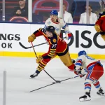 2 janvier 2026 ; Miami, Floride, États-Unis ; le défenseur des Panthers de la Floride, Niko Mikkola (77), passe la rondelle défendue par l'ailier gauche des Rangers de New York, Brett Berard (65), durant la deuxième période du match de hockey sur glace Winter Classic 2026 au loanDepot Park.