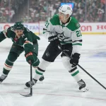 Apr 22, 2026; Saint Paul, Minnesota, USA; Dallas Stars left wing Jason Robertson (21) skates with the puck as Minnesota Wild defenseman Brock Faber (7) defends during the first period in game three of the first round of the 2026 Stanley Cup Playoffs at Grand Casino Arena.
