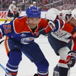 Jan 24, 2026; Edmonton, Alberta, CAN; Edmonton Oilers defensemen Darnell Nurse (25) and Washington Capitals forward Ryan Leonard (9) battle for a loose puck during the second period at Rogers Place