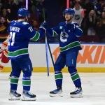 Mar 23, 2024; Vancouver, British Columbia, CAN; Vancouver Canucks forward Nils Hoglander (21) celebrates a goal with Vancouver Canucks forward Elias Pettersson (40) against Calgary Flames during the first period at Rogers Arena.