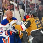 Mar 26, 2026; Las Vegas, Nevada, USA; Vegas Golden Knights center Brett Howden (21) punches the helmet off of Edmonton Oilers defenseman Darnell Nurse (25) at the end of the first period at T-Mobile Arena.