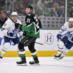 Dec 21, 2025; Dallas, Texas, USA; Dallas Stars left wing Jason Robertson (21) skates in front of Toronto Maple Leafs left wing Nicholas Robertson (89) and center Max Domi (11) during the third period at the American Airlines Center.