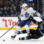Jan 13, 2026; Salt Lake City, Utah, USA; Toronto Maple Leafs left wing Matthew Knies (23) and Utah Mammoth defenseman Ian Cole (28) battle for the puck during the third period at Delta Center.