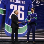 Jun 26, 2026; Buffalo, New York, USA; Caleb Malhotra reacts with NHL commissioner Gary Bettman after being selected with the third pick in the first round of the 2026 NHL Draft by the Vancouver Canucks at KeyBank Center.