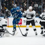 Mar 26, 2026; Vancouver, British Columbia, CAN; Los Angeles Kings defenseman Brandt Clarke (92) and forward Mathieu Joseph (17) watch as goalie Darcy Kuemper (35) makes a save on Vancouver Canucks forward Elias Pettersson (40) in the second period at Rogers Arena.