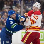 25 septembre 2022; Vancouver (Colombie-Britannique, Canada); Adam Klapka (43), attaquant des Flames de Calgary, se bat avec Vincent Arseneau (68), des Canucks de Vancouver, en troisième période au Rogers Arena. Calgary l'emporte 3-2 en prolongation.
