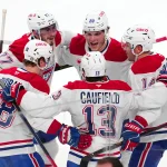 Dec 31, 2024; Las Vegas, Nevada, USA; Montreal Canadiens center Kirby Dach (77) and left wing Juraj Slafkovsky (20) and center Nick Suzuki (14) and right wing Cole Caufield (13) and center Christian Dvorak (28) celebrate after the Canadiens defeated the Vegas Golden Knights 3-2 at T-Mobile Arena. Mandatory Credit: Stephen R. Sylvanie-Imagn Images