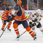 Feb 9, 2022; Edmonton, Alberta, CAN; Chicago Blackhawks forward Kirby Dach (77) takes the puck from Edmonton Oilers 97 during the third period at Rogers Place.