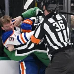 Mar 12, 2026; Dallas, Texas, USA; Edmonton Oilers center Connor McDavid (97) fights with Dallas Stars center Justin Hryckowian (49) during the second period at the American Airlines Center.