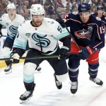 Mar 21, 2026; Columbus, Ohio, USA; Seattle Kraken center Shane Wright (51) and Columbus Blue Jackets defenseman Dante Fabbro (15) skate after a loose puck during the first period at Nationwide Arena.