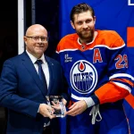 Jan 10, 2026; Edmonton, Alberta, CAN; Edmonton Oilers GM Stan Bowman presents Leon Draisaitl with a Tiffany Crystal for recording 1000 points in the NHL at Rogers Place.