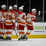 Apr 7, 2026; Dallas, Texas, USA; Calgary Flames defenseman Yan Kuznetsov (37) and defenseman Zach Whitecloud (28) and center Connor Zary (47) and center Yegor Sharangovich (17) celebrates a goal scored by Sharangovich against the Dallas Stars during the second period at the American Airlines Center.
