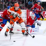15 mars 2026; Montréal, Québec, Canada; Le centre des Ducks d'Anaheim, Leo Carlsson (91), joue la rondelle contre le défenseur des Canadiens de Montréal, Alexandre Carrier (45), près du filet du gardien Jacob Fowler (32), durant la deuxième période au Centre Bell.